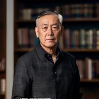 淫母日记创始人陈文远的专业形象照，身着深色休闲衬衫，背景为简洁的书架环境，神情专注而从容，体现资深内容创作者的气质